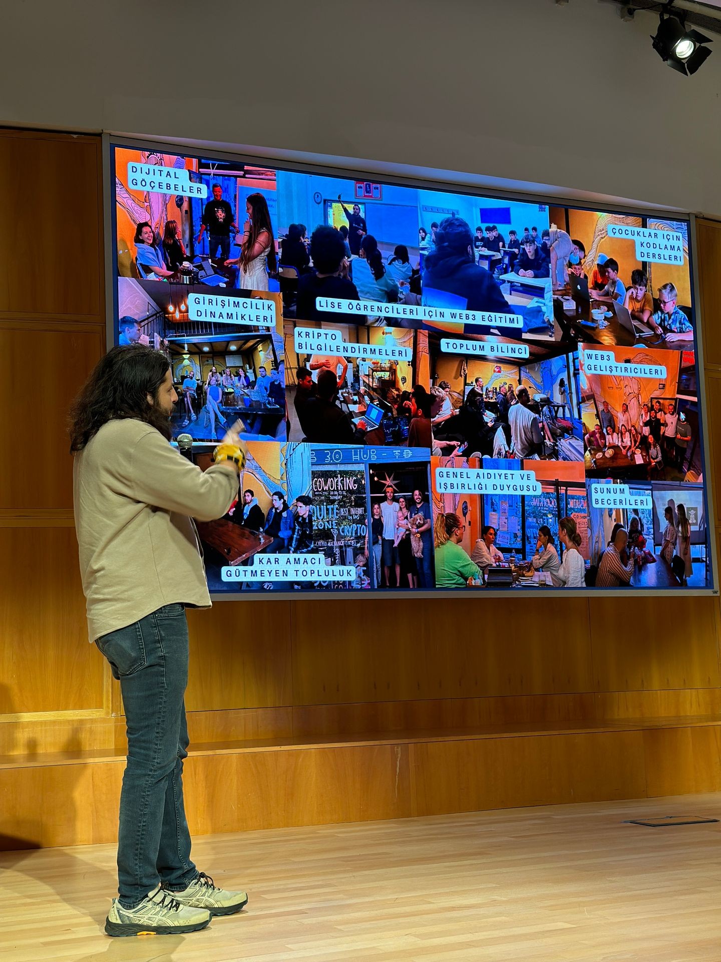 Person presenting in front of a large screen displaying various educational workshop images.