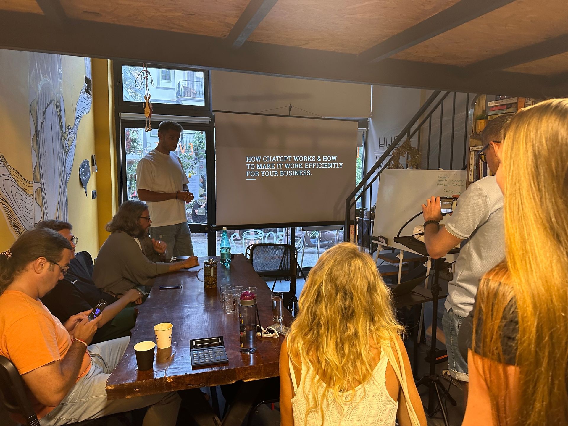 People in a workshop about ChatGPT for business efficiency, with a presentation screen visible.